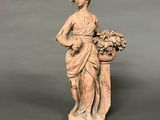 statue of a woman with a basket of flowers on a pedestal