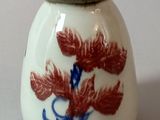 un vase blanc orné d'un motif rouge et bleu