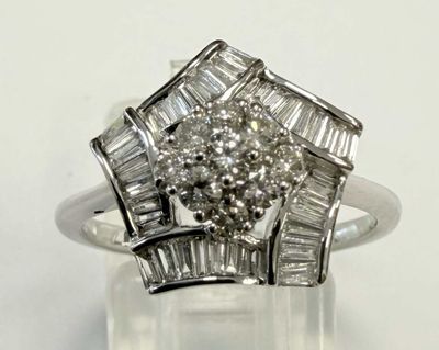 une photo d'une bague en diamant et en or blanc posée sur une surface claire