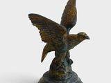 statue en bronze représentant un oiseau sur un socle, sur fond blanc