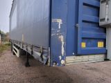 a large blue truck that is parked on the side of the road