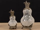 two glass vases sitting on top of a table next to each other