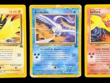 three pokemon cards on a table with a black background
