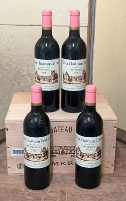 four bottles of red wine sit in a wooden crate on a table