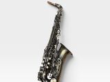 un gros plan d'un saxophone posé sur une surface blanche