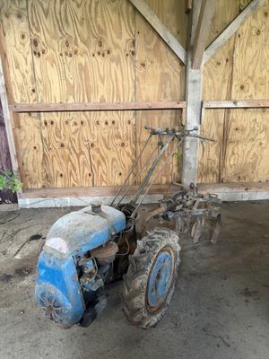 un tracteur bleu garé à l'intérieur d'un bâtiment