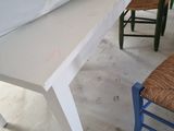 une table blanche avec une chaise bleue devant