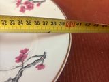 un mètre ruban posé sur une assiette décorée d'une fleur