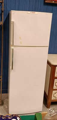 a white refrigerator sitting in the middle of a room