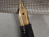 a pen with a gold nib sitting on top of it