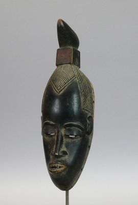 Masque "Gu" en bois dur à patine sombre figurant un fin visa…