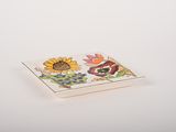 small ceramic dish with a flower design on the side