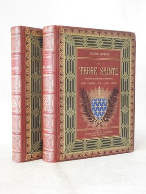 two red books sitting on top of each other on a white surface