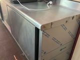 a metal counter with a microwave on top of it