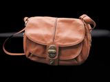 brown leather purse on a black background