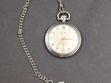 une montre à gousset en argent à laquelle est attachée une chaîne