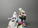 figurine of a man and woman sitting on a bench with a dog
