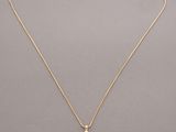 un collier en or avec un pendentif en pierre blanche