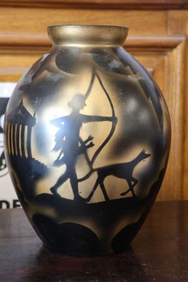 un vase noir et doré posé sur une table en bois