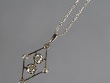 a close up of a diamond necklace on a silver chain