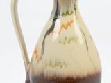 a brown and white pitcher on a white background