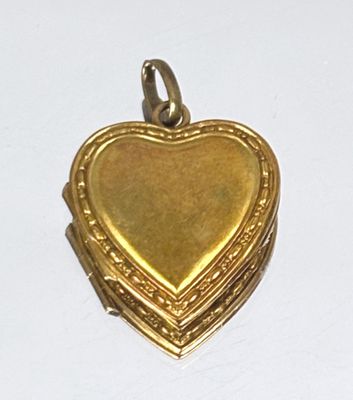 a gold heart shaped locke on a white surface