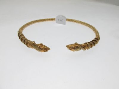 a close up of a gold bracelet on a white surface