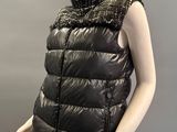 mannequin wearing a black vest and black pants with a chain around the neck