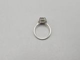a close up of a diamond ring on a white surface