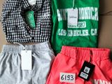 Trois shorts et un t-shirt se trouvent dans une boîte en carton