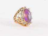gros plan d'une bague avec une pierre violette entourée de diamants