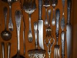 many spoons and spoon knives in a wooden box