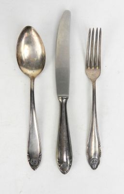 trois fourchettes, une cuillère et un couteau posés sur une table