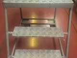 a metal table with three steps on it in a room