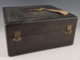 a black box with a gold handle and a tag on it