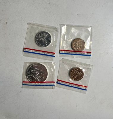 quatre pièces se trouvent dans de petits sachets en plastique posés sur une surface blanche