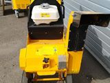a small yellow machine that is parked in front of a building