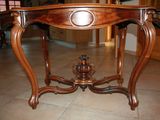 a wooden table with a marble top on a tile floor