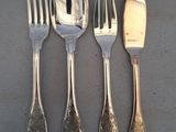 quatre fourchettes, un couteau et une cuillère posés sur une table