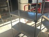 une étagère métallique avec des tablettes, placée au milieu d'une pièce