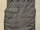 the back of a gray vest hanging on a wall