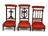 trois chaises dont les assises sont recouvertes de tissu rouge et dont le dossier est orné d'une croix