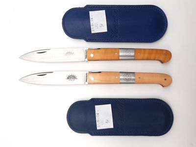 three different types of knives are lined up on a white surface