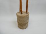 deux bâtonnets en bois qui dépassent d'un vase posé sur une surface blanche