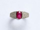 un gros plan d'une bague ornée d'un rubis entouré de diamants