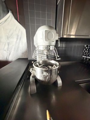 un mixeur posé sur le plan de travail de la cuisine, à côté d'un saladier
