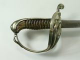 a close up of a sword on a white surface