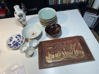 de nombreux bols et assiettes posés sur une table, avec une bibliothèque en arrière-plan