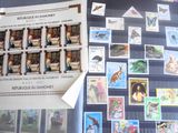 beaucoup de timbres posés sur une table, à côté d'une feuille de papier