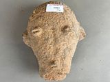 an image of a stone head with a tag on it